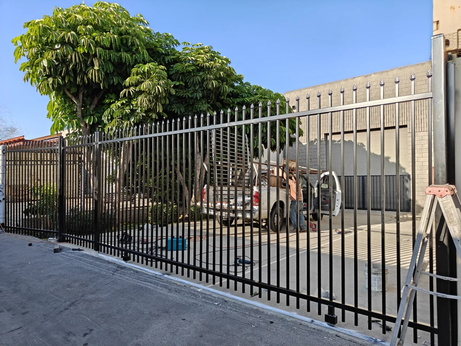 Black steel double-swing driveway security gate, angled view, Los Angeles