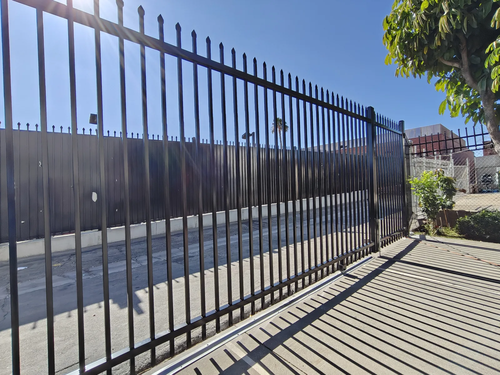 Black spear-top steel security fence along a Los Angeles commercial yard by Apexguard Fence