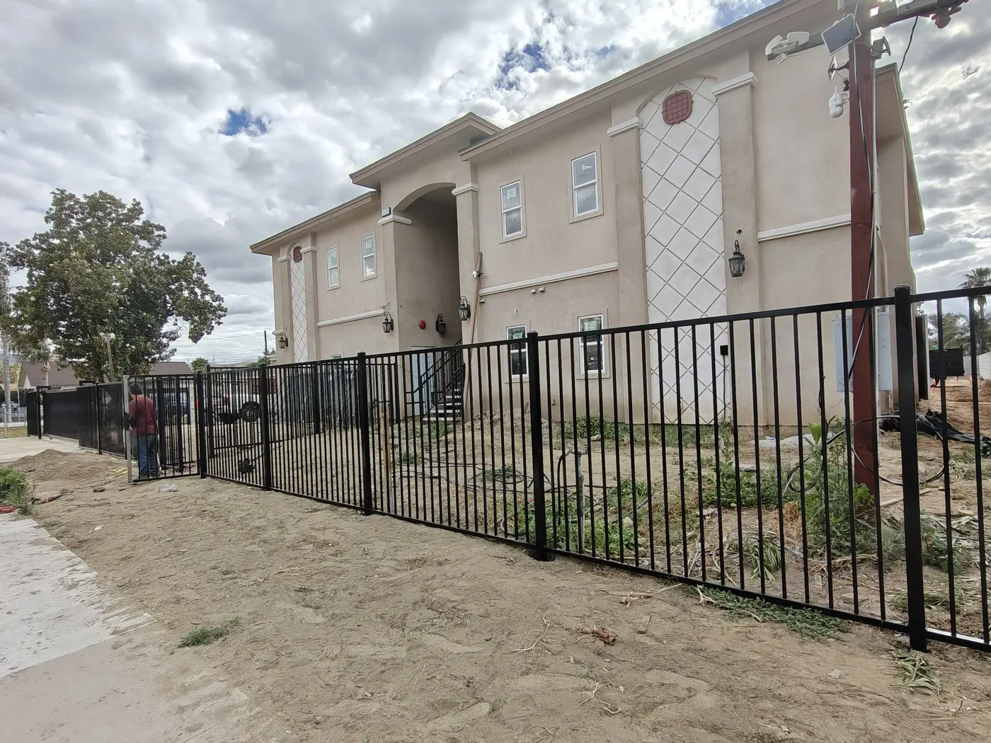 Black steel flat-top perimeter fence along the street frontage of a condo community in Fontana, CA