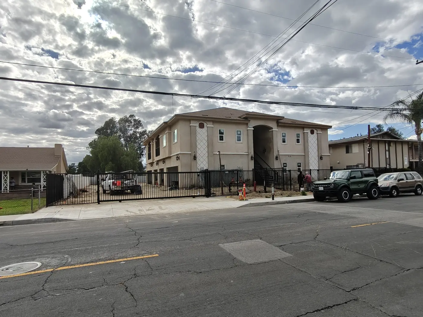 Automatic black steel sliding driveway gate at the entrance of a Fontana condo community