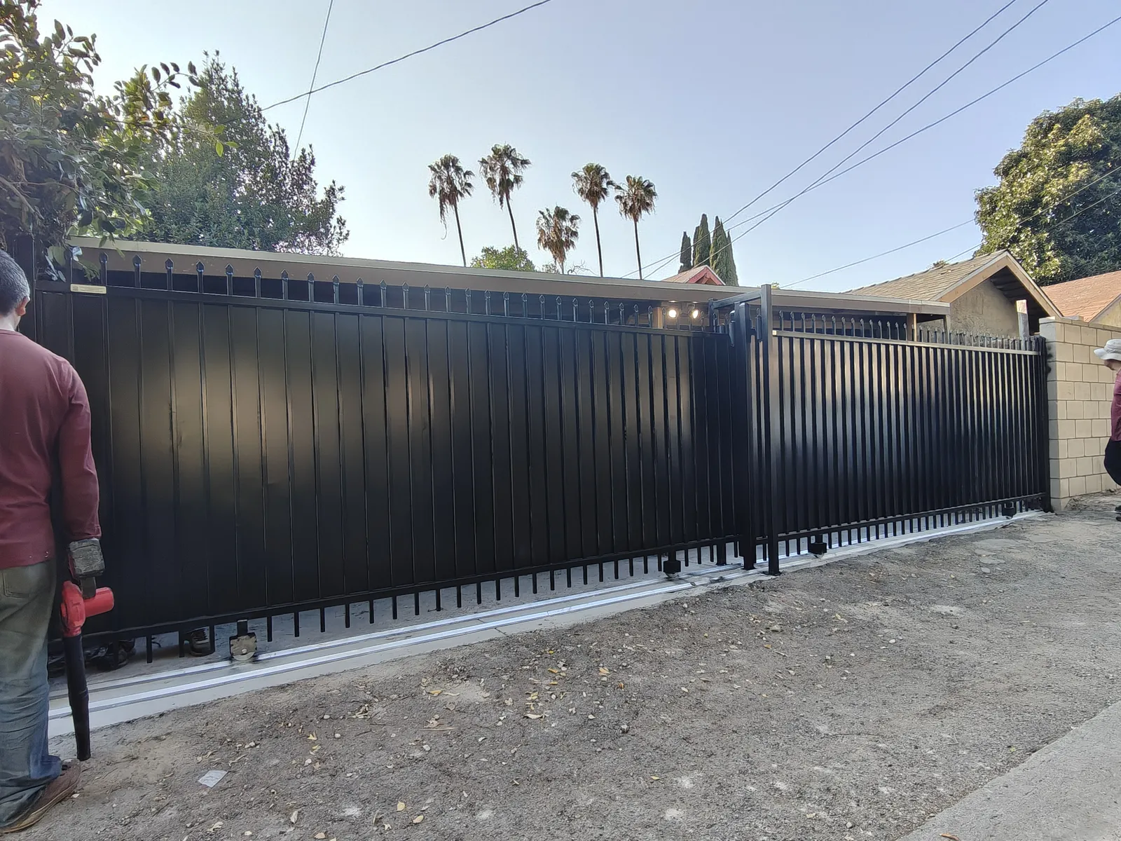 Two independent sliding driveway gates from one 26-foot opening for two tenants in Los Angeles