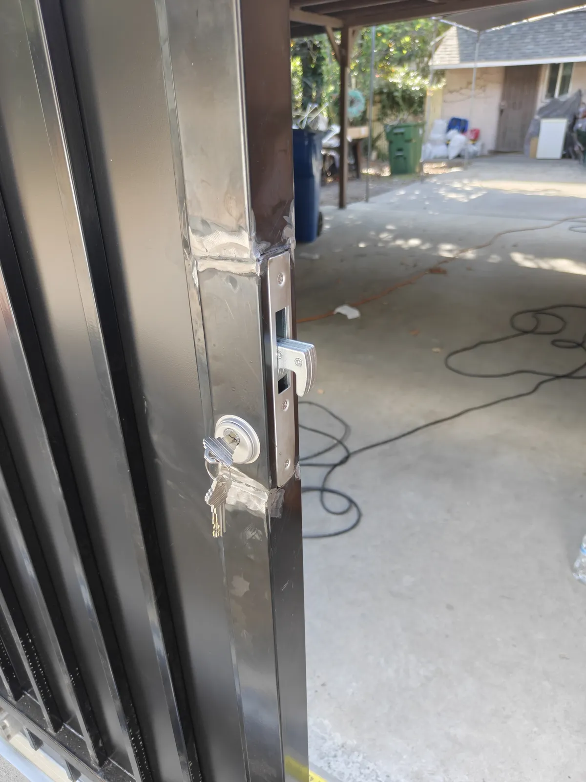 Separate keyed hook lock for each tenant on a sliding driveway gate