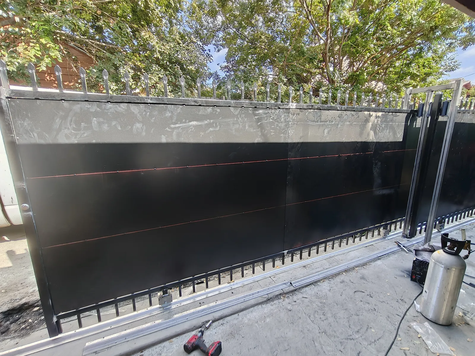 Sliding gate with solid steel privacy panel welded on site in Los Angeles