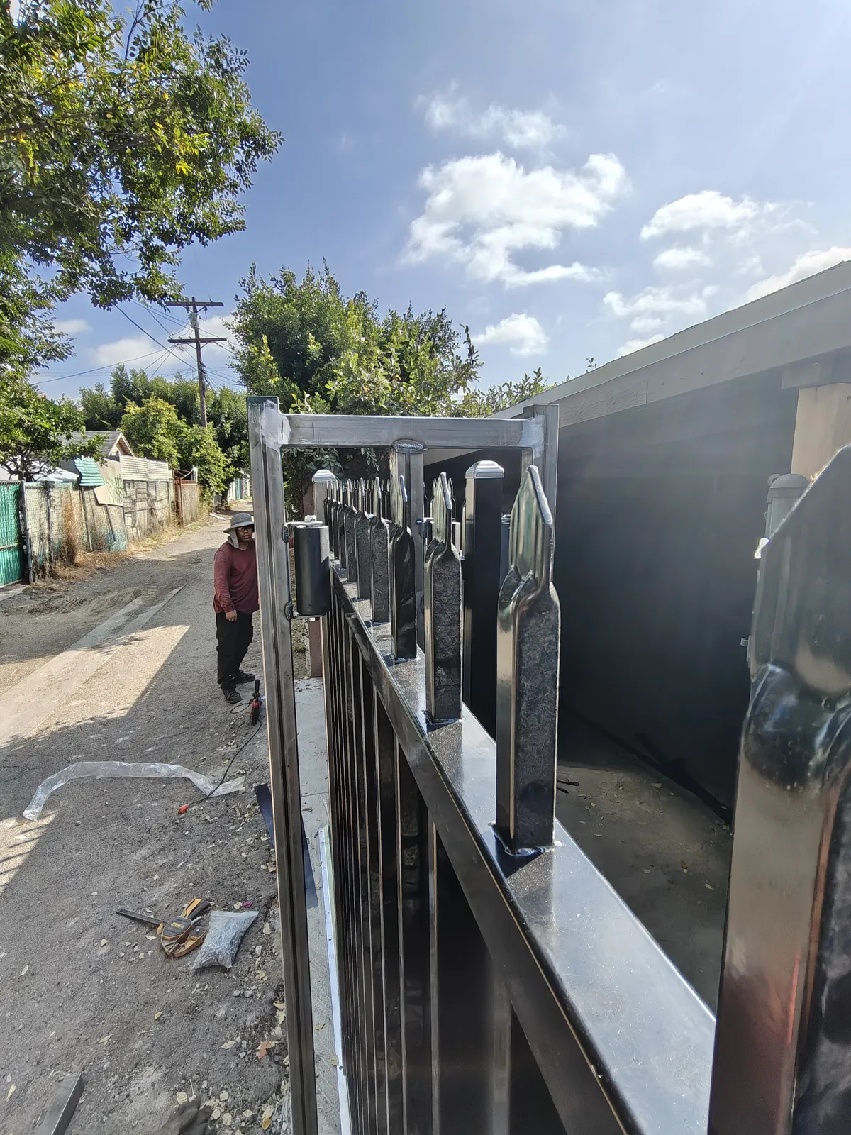 Spear-top steel sliding gate detail over a solid privacy panel, Los Angeles