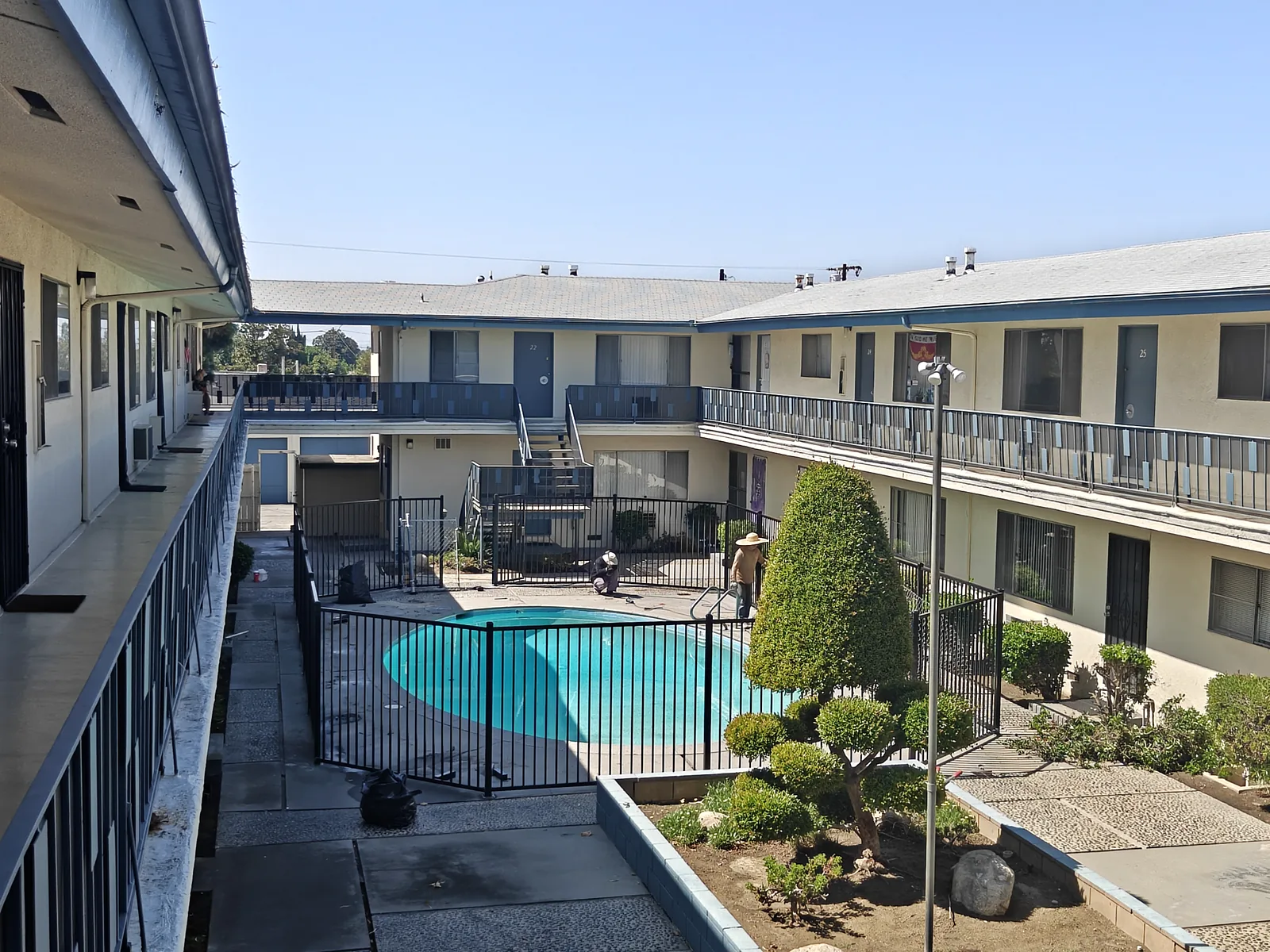 Black ornamental iron pool enclosure and gate at an apartment courtyard pool — a real Apexguard Fence project in West Covina, CA