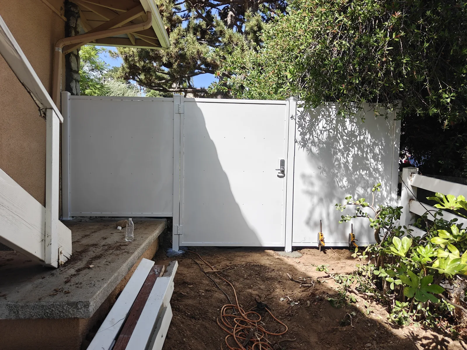 White solid steel walk gate and privacy fence at a side entrance in West Covina, CA by Apexguard Fence