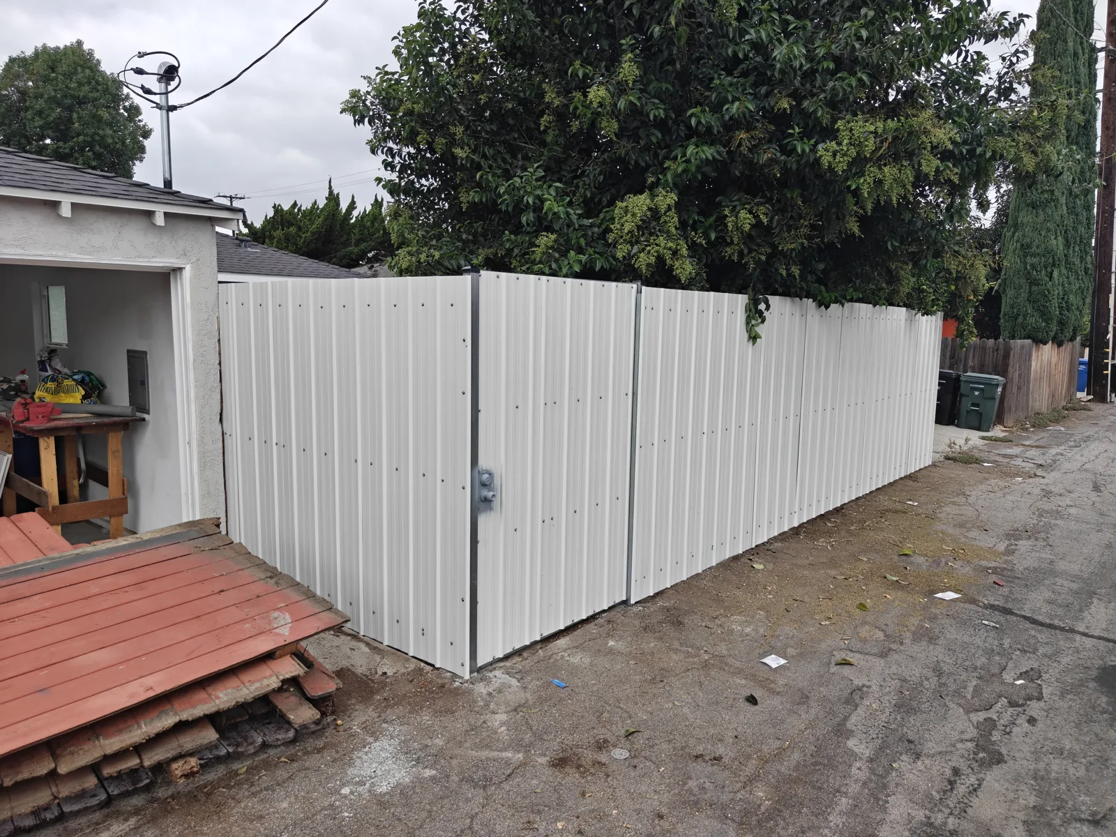 White corrugated steel privacy fence with integrated access door in Whittier, CA by Apexguard Fence