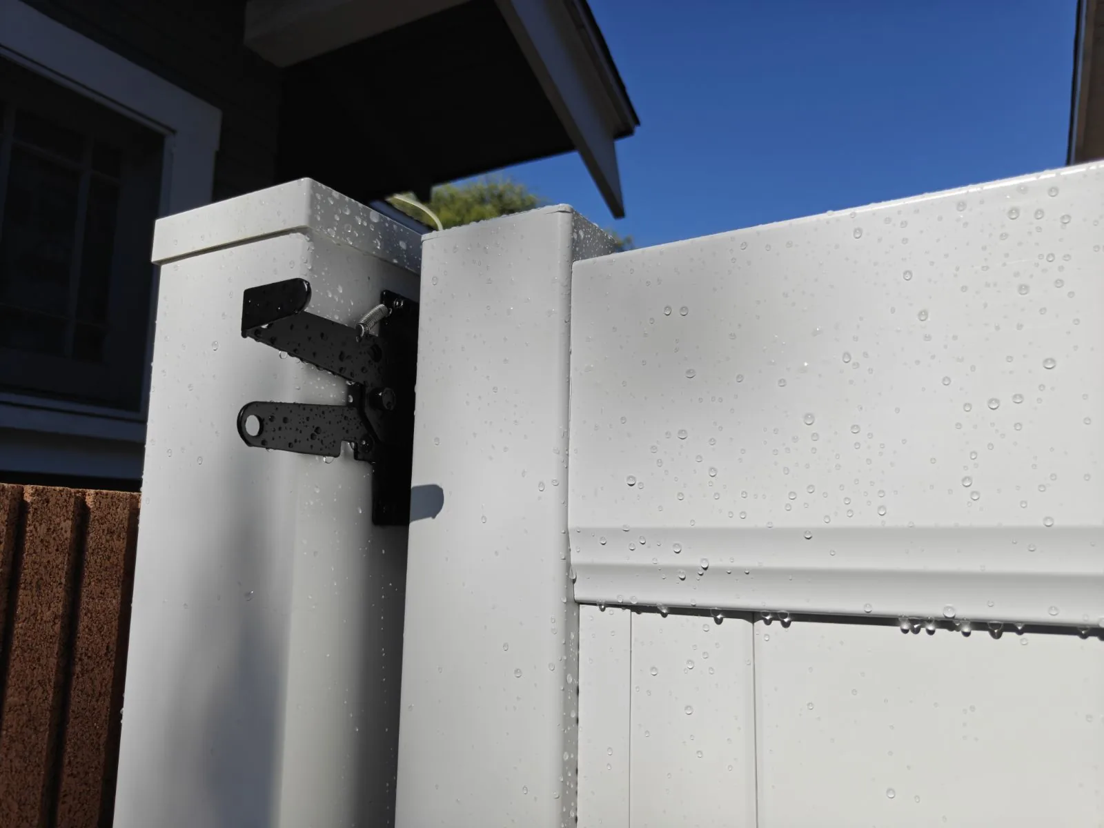 Self-closing spring hinge on an aluminum-reinforced vinyl gate post in Whittier, CA