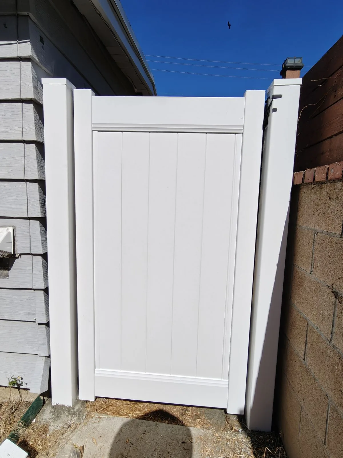 Second white vinyl privacy gate with concrete-filled posts in Whittier, CA by Apexguard Fence