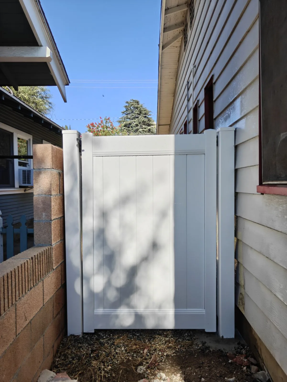 White vinyl side-yard gate between house and block wall in Whittier, CA by Apexguard Fence